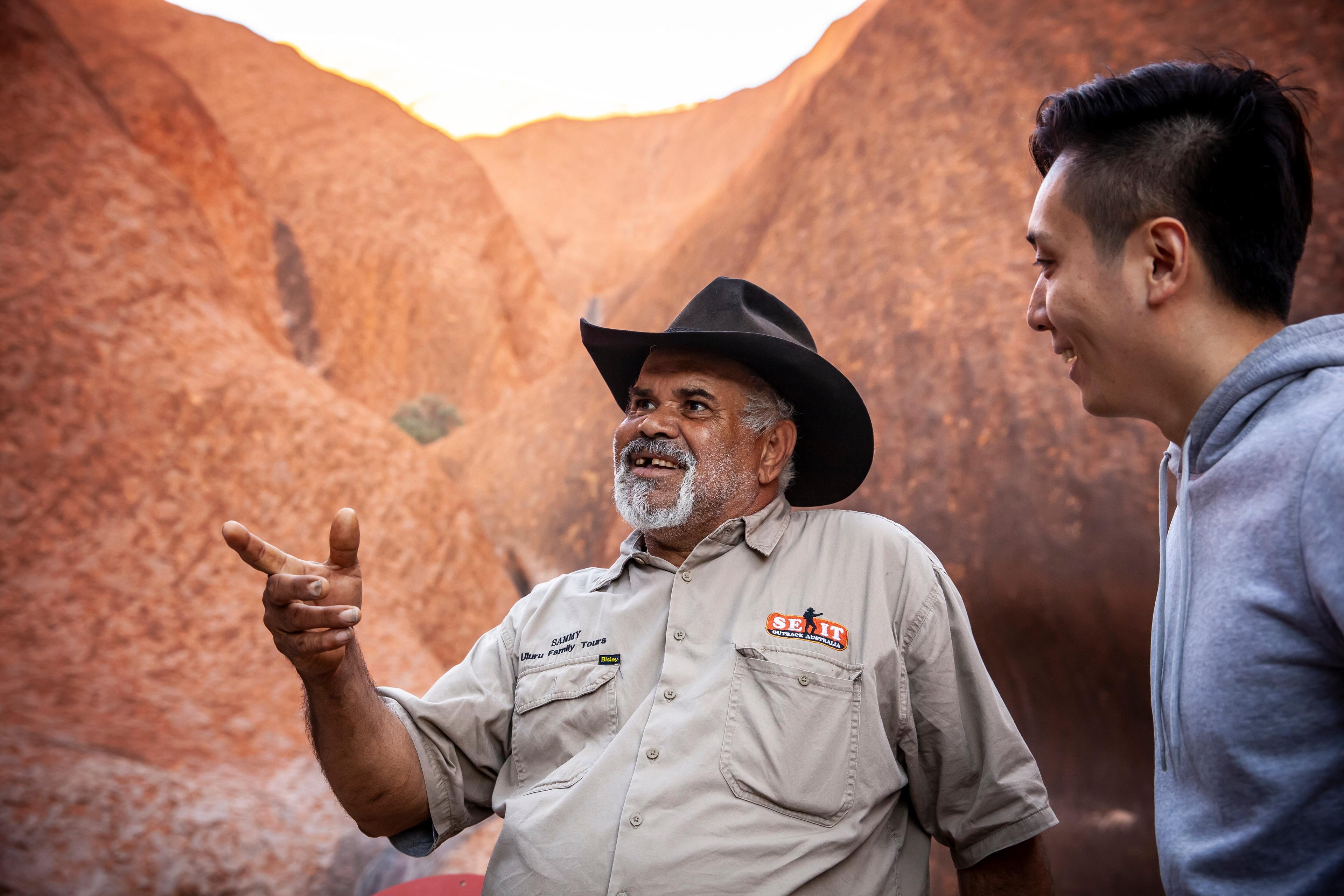 Two men beside Ayers Rock